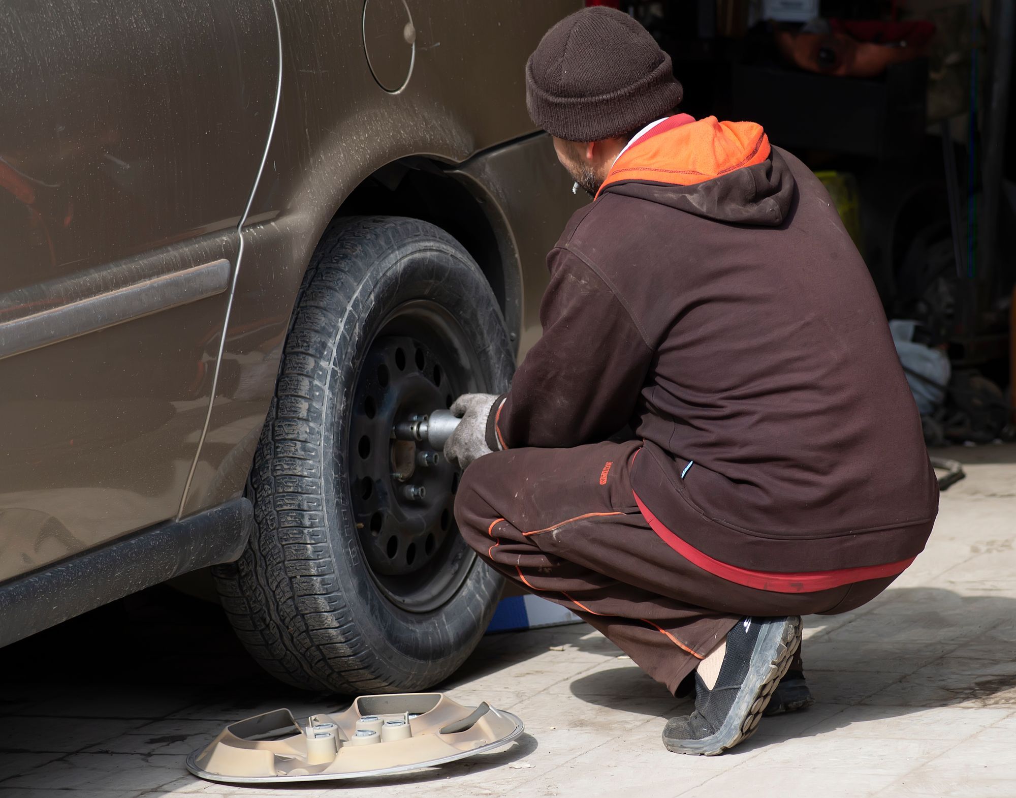 Mechanik při výměně kola osobního auta