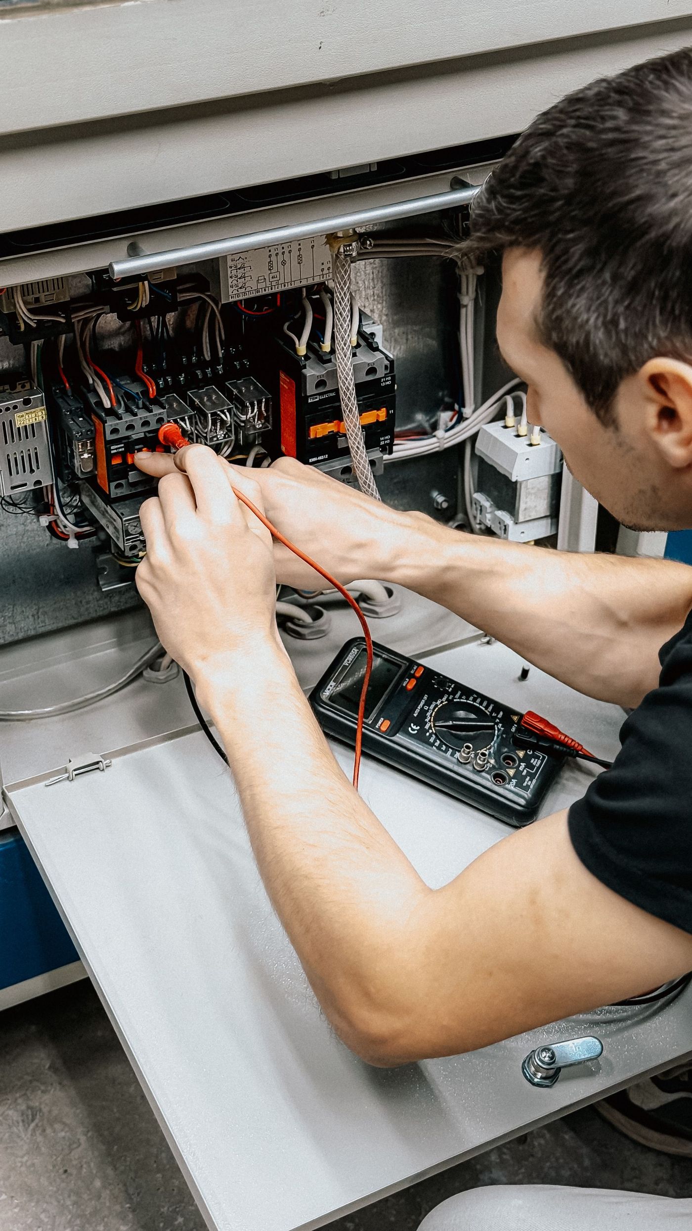 Elektrikář zkouší zapojení vodičů v rozvaděči