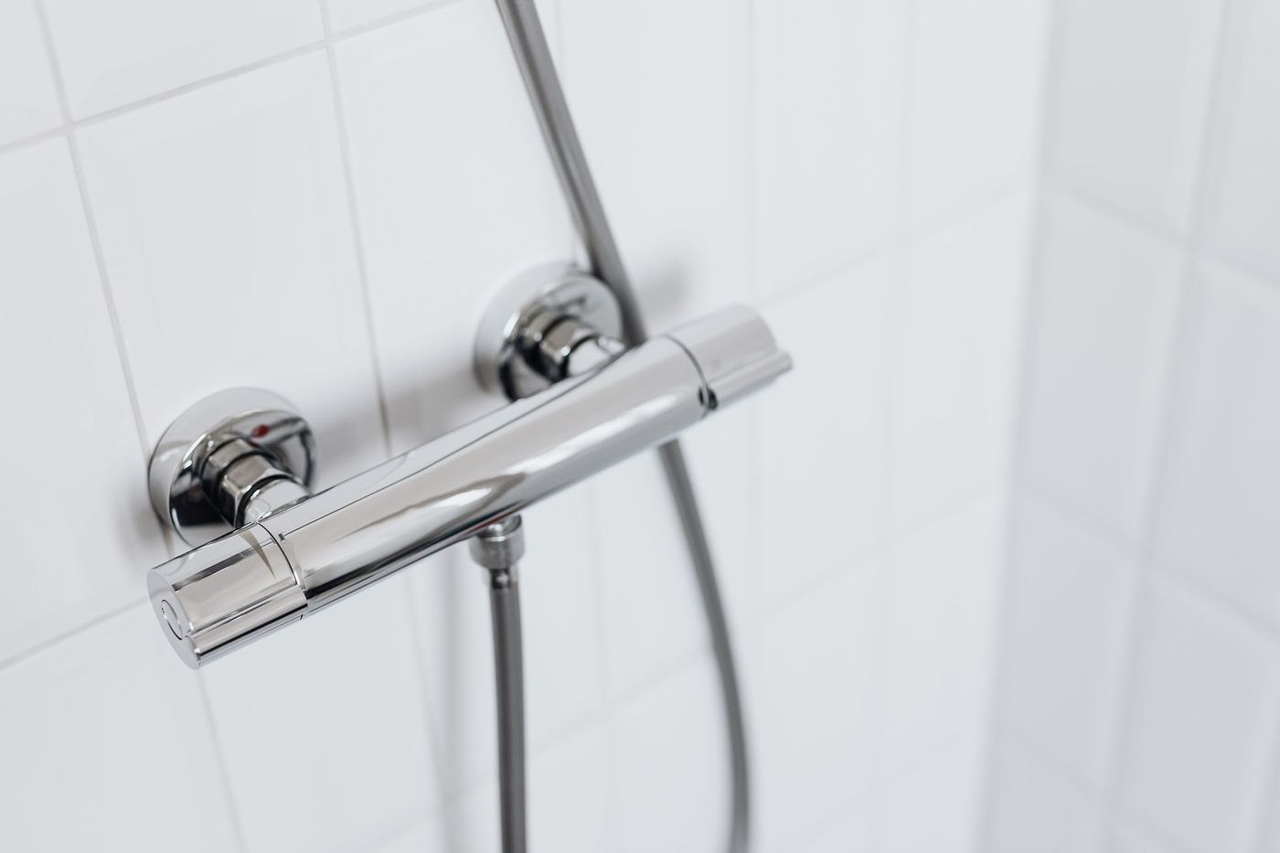 Termostatická sprchová baterie na bílém obkladu